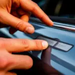 Proč mají auta v rámu dveří tento kovový háček